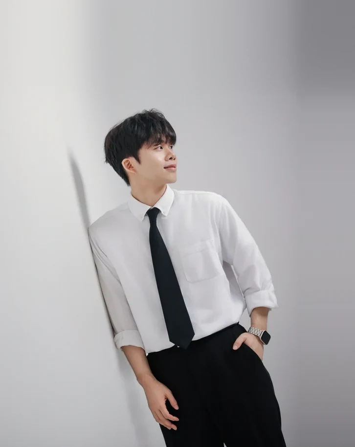 Founder Hajun Kim looking to the side in a white shirt and black tie